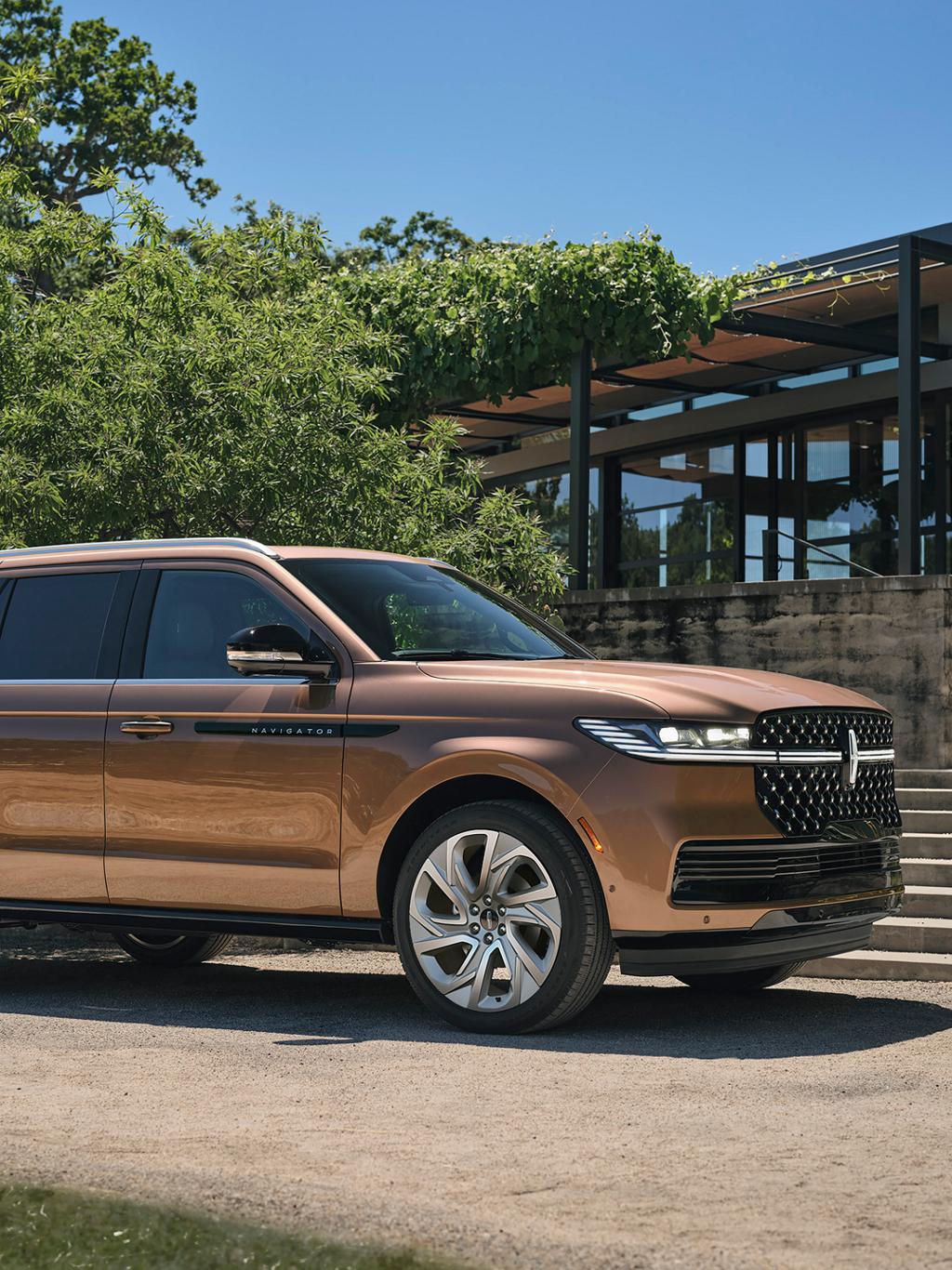 Una SUV Lincoln Black Label Navigator® 2025 está estacionada junto a una casa de estilo moderno
